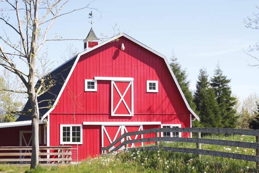 Red and white barn with fence in foreground
